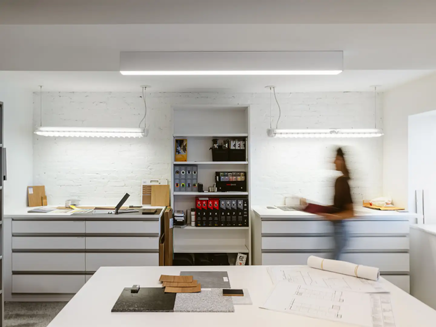 Espace de travail moderne avec éclairage ajusté et solutions de rangement intégrées, offrant un environnement organisé et fonctionnel.