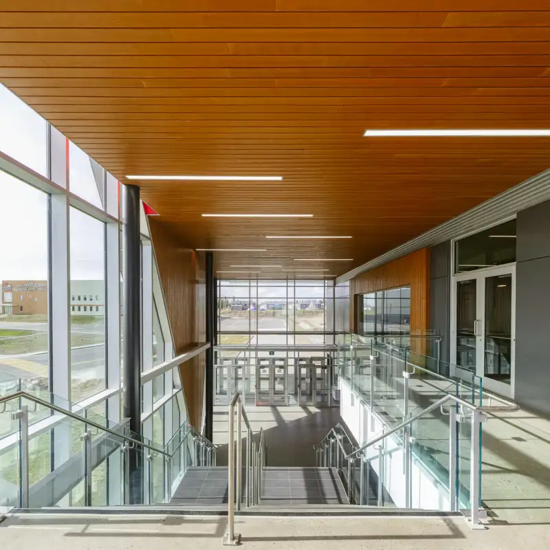 Premier niveau de l’aréna de Wemindji : un espace accueillant avec un plafond en bois chaleureux, créant une ambiance conviviale et élégante.